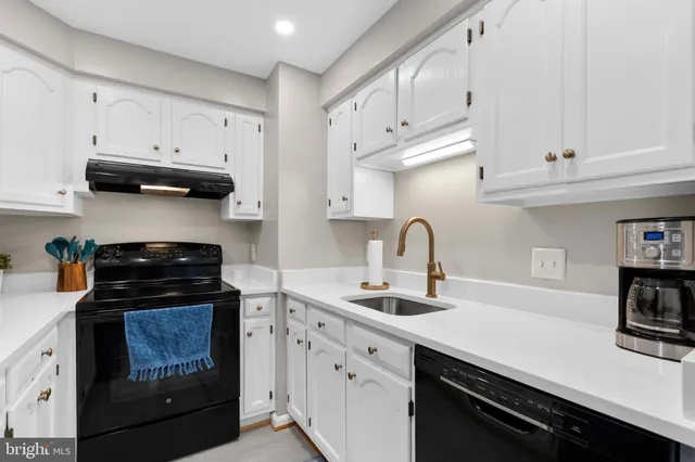 a kitchen with white cabinets and appliances