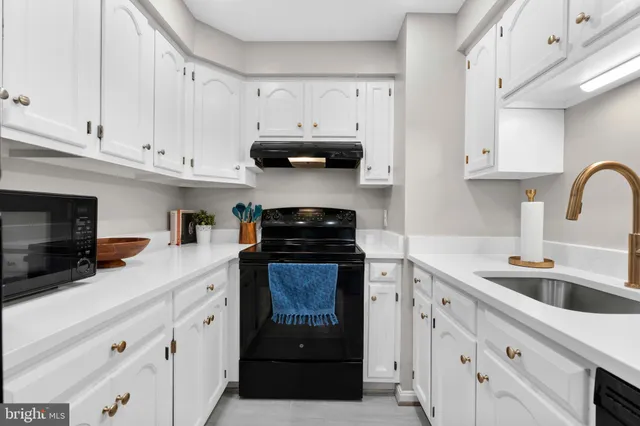 a kitchen with cabinets appliances a sink and a counter space