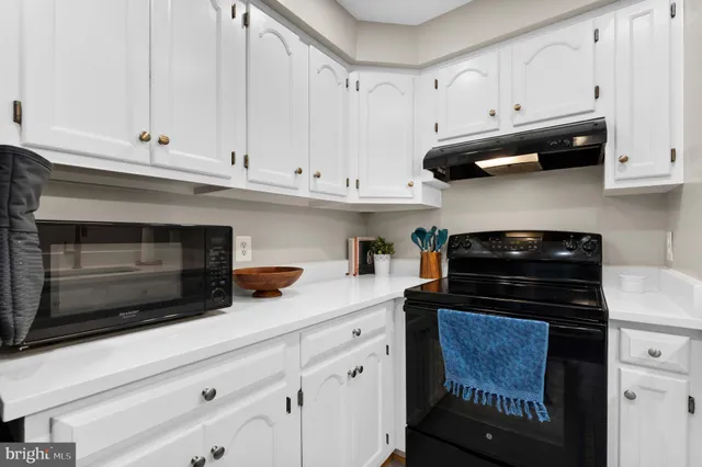 a kitchen with white cabinets and appliances
