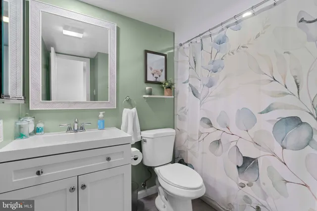 a bathroom with a granite countertop toilet sink and mirror