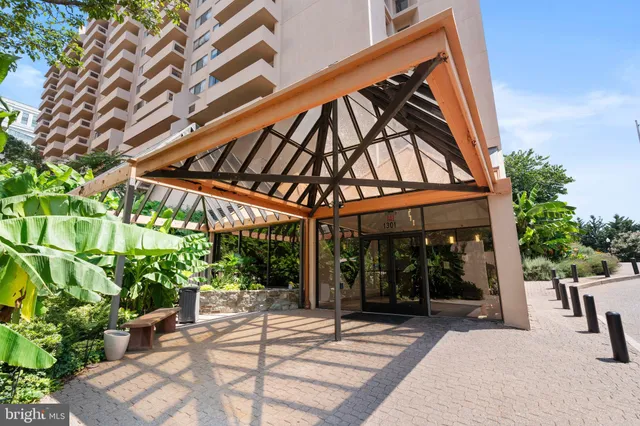 a view of a patio with a table and chairs under an umbrella with a small yard