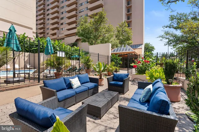 a view of a patio with couches a table and chairs and potted plants