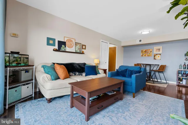 a living room with furniture a rug and kitchen view
