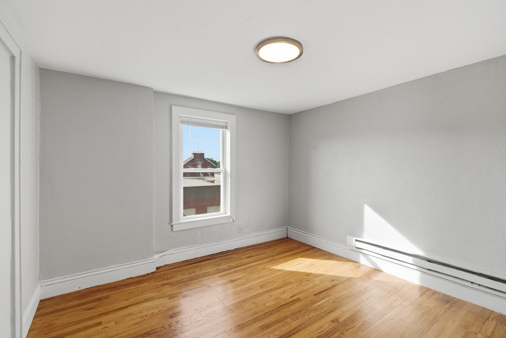 293 Clemente Street, Unit 3R Holyoke, MA 01040 - Photo 5 of 14 a view of empty room with wooden floor and fan