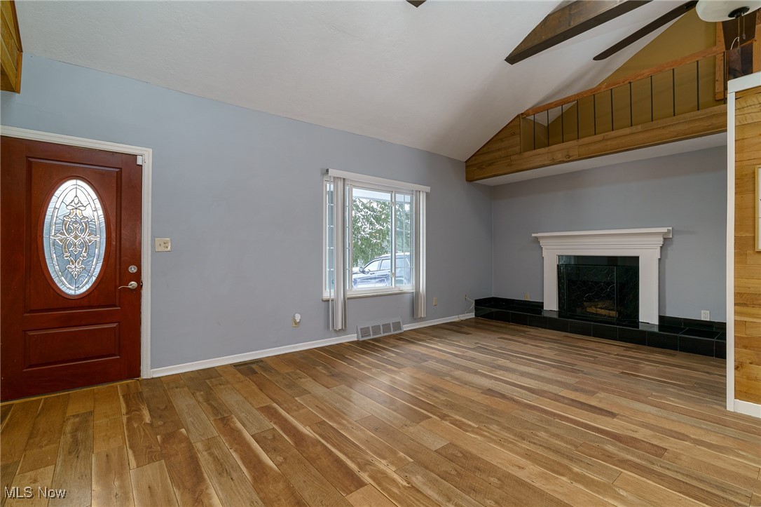 3165 East Sprague Road Independence, OH 44131 - Photo 6 of 41 living room with uxury vinyl flooring, vaulted ceiling and fireplace