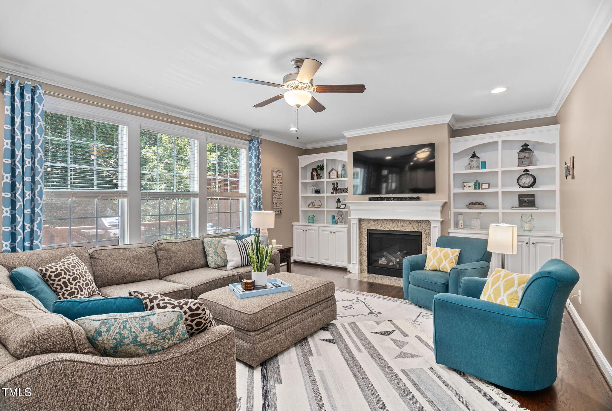 2712 Lake Waccamaw Trail Apex, NC 27502 - Photo 10 of 41 a living room with furniture a fireplace and a flat screen tv