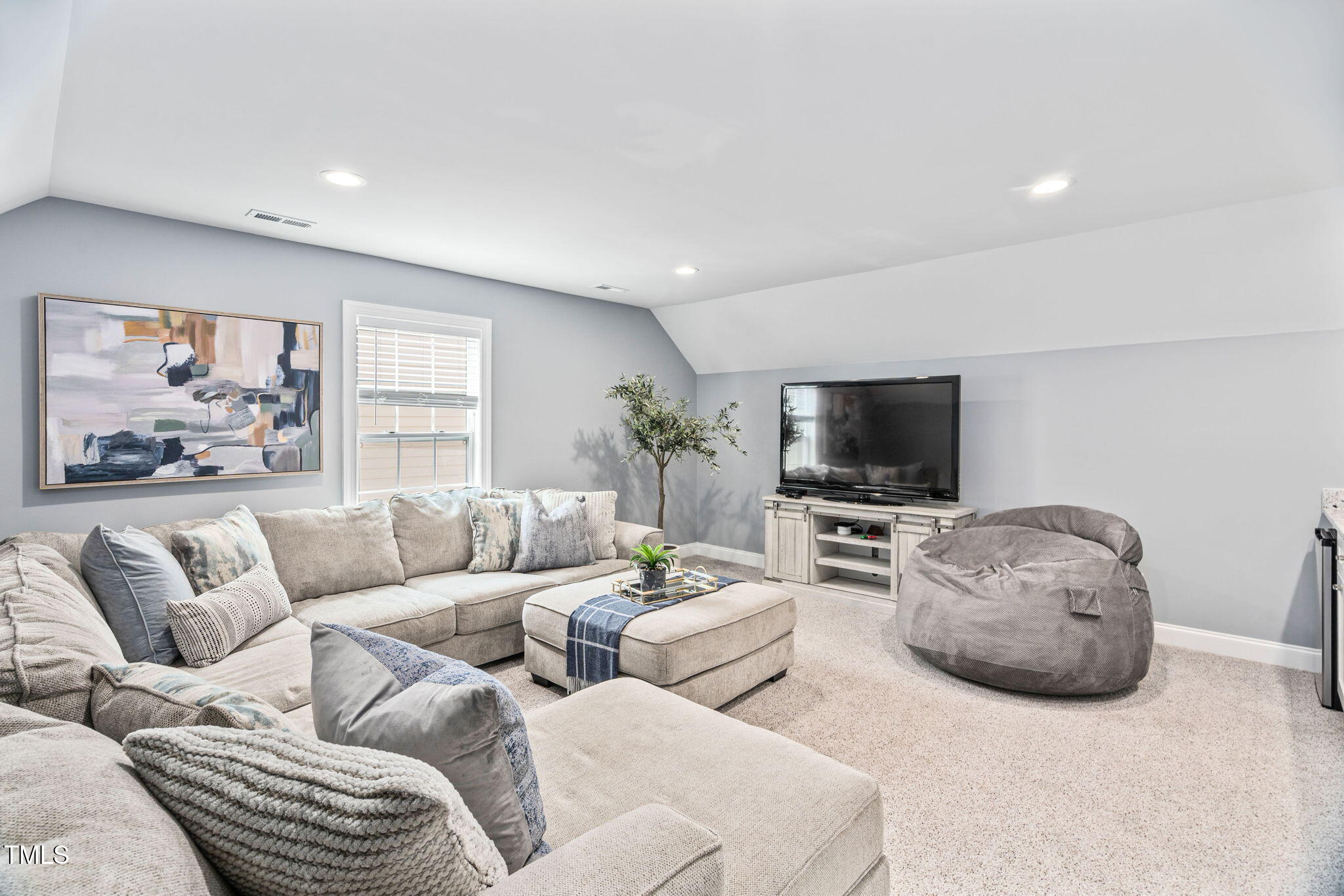 2712 Lake Waccamaw Trail Apex, NC 27502 - Photo 23 of 41 a living room with furniture and a flat screen tv
