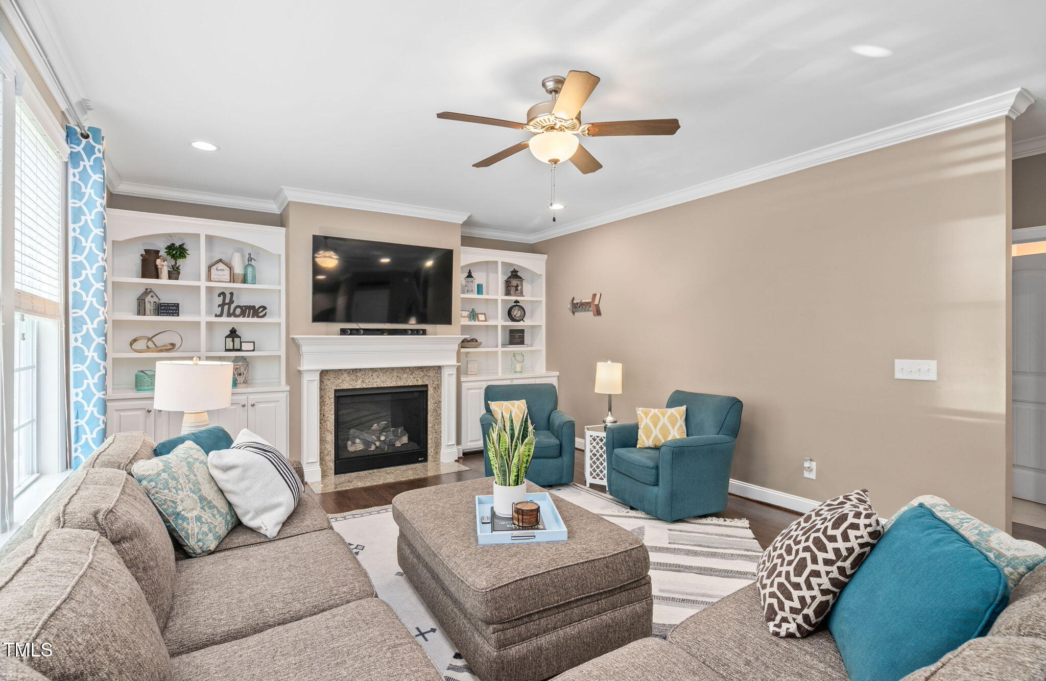 2712 Lake Waccamaw Trail Apex, NC 27502 - Photo 2 of 41 a living room with furniture a flat screen tv and a fireplace