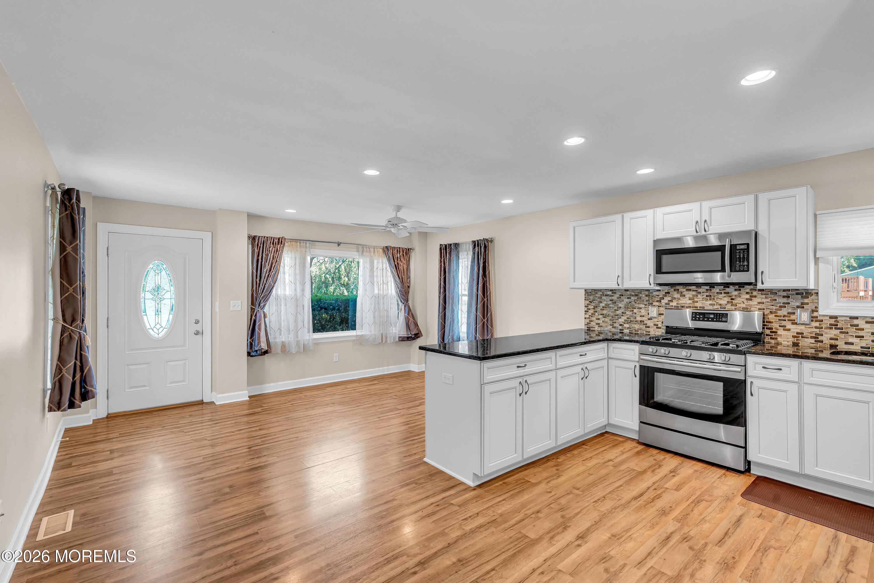 1407 Edgemere Road Wall, NJ 07719 - Photo 4 of 16 a kitchen with granite countertop a stove a sink and a refrigerator