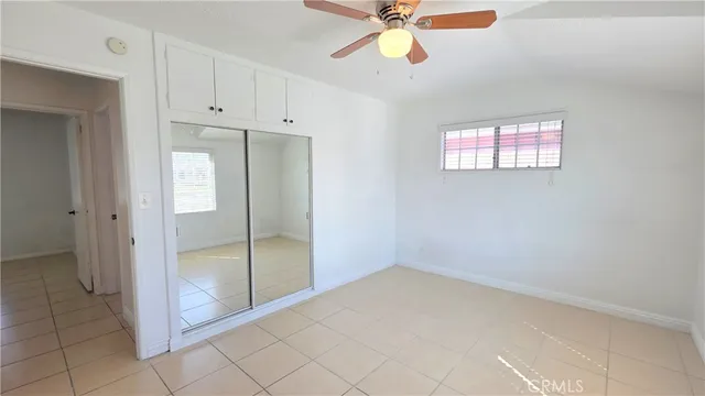 an empty room with closet and windows