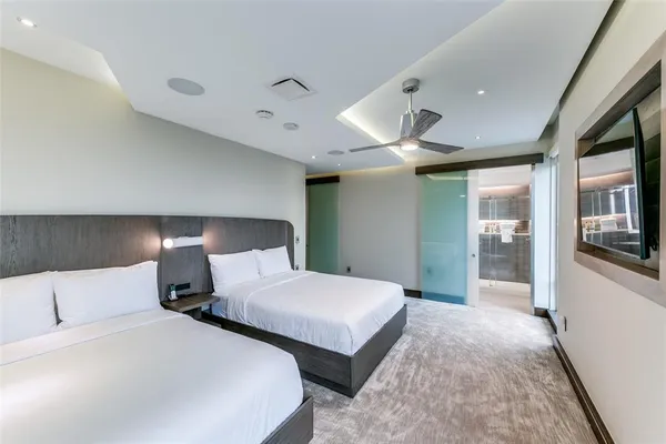 a bedroom with two large bed and a chandelier