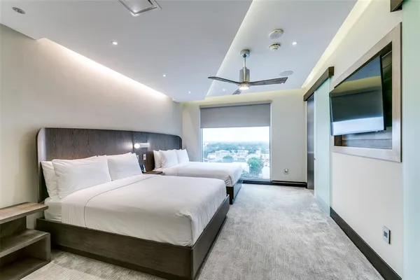 a bedroom with a bed and a large window