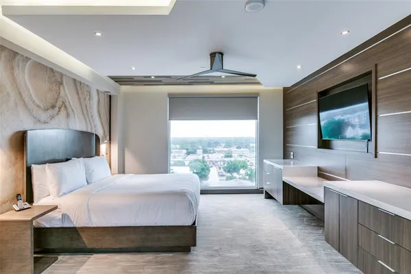 a spacious bedroom with a bed and a large window