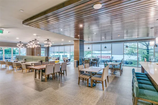 a room with lots of tables a large window and chairs