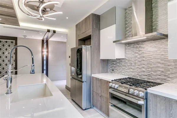 a kitchen with stainless steel appliances granite countertop a sink stove and refrigerator