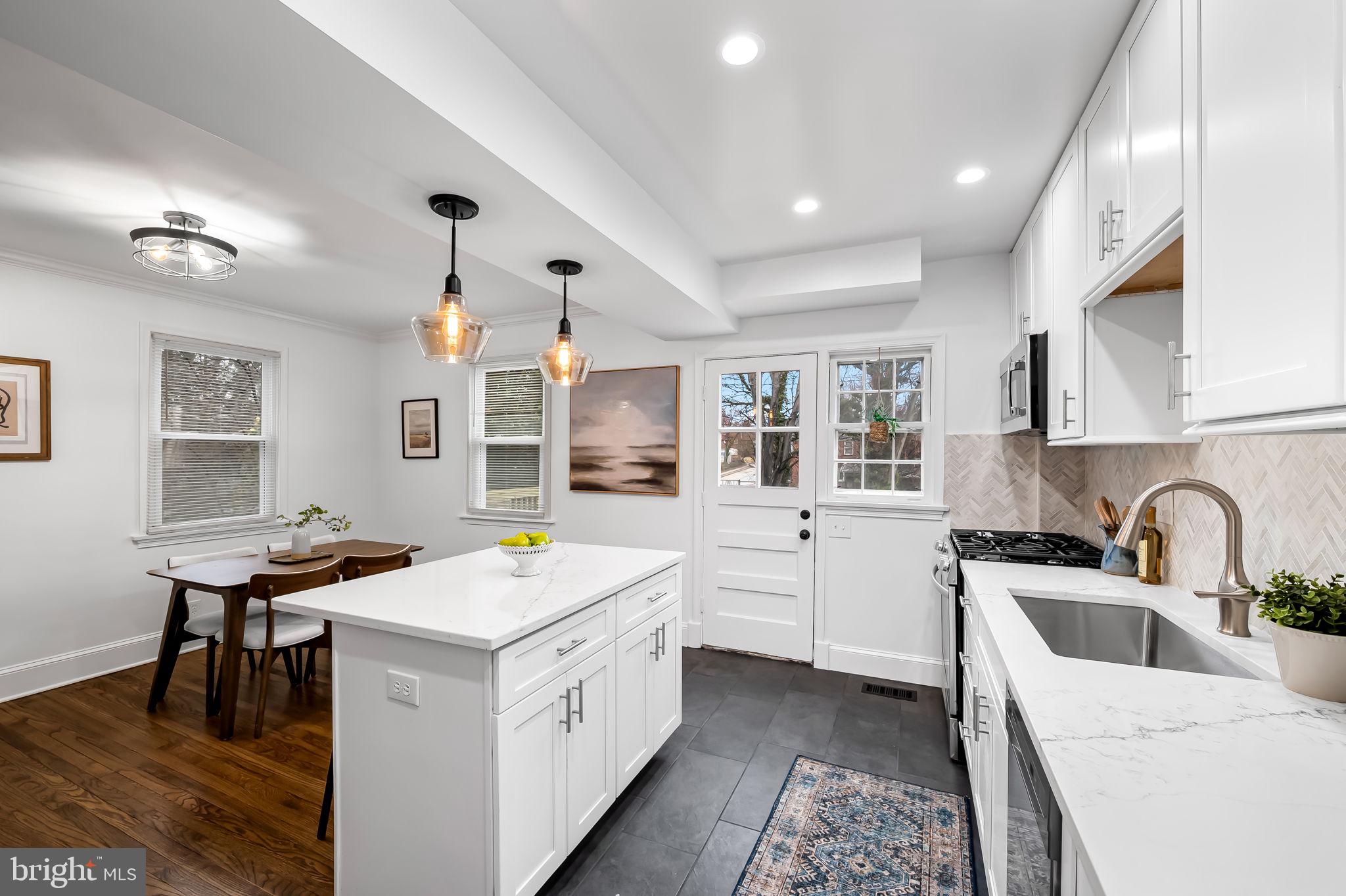 834 Evesham Avenue Baltimore, MD 21212 - Photo 11 of 37 a kitchen that has a sink a stove counter top space and a window in it