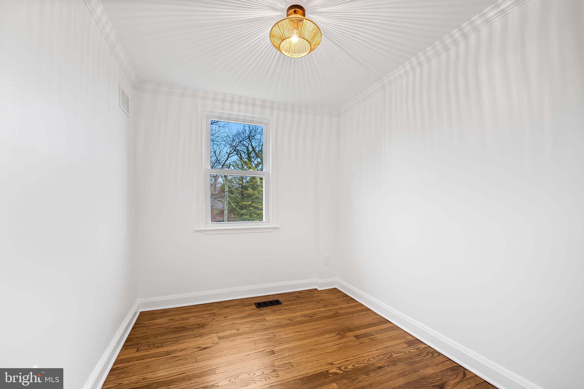834 Evesham Avenue Baltimore, MD 21212 - Photo 21 of 37 a view of empty room with window and wooden floor