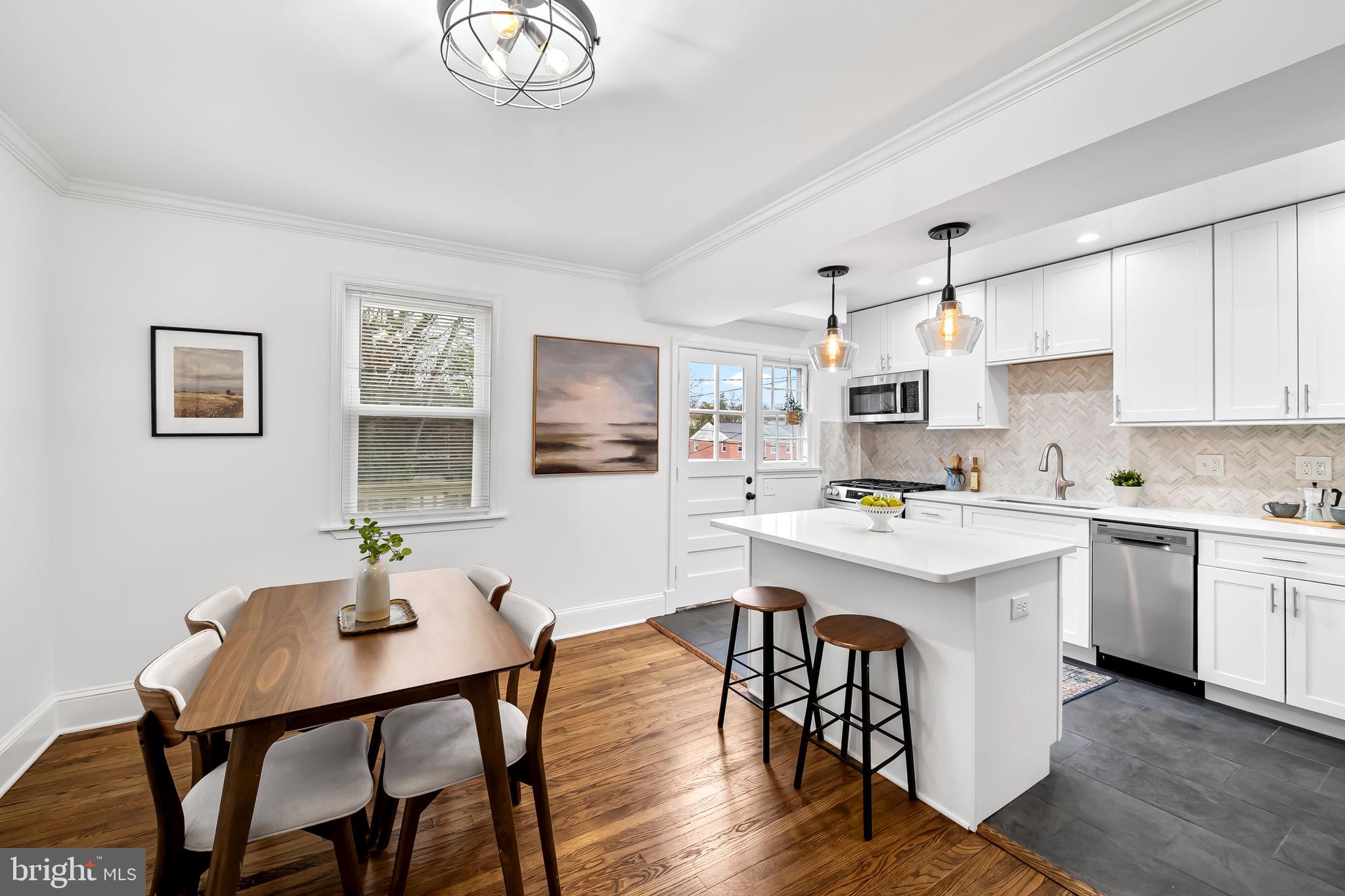 834 Evesham Avenue Baltimore, MD 21212 - Photo 8 of 37 a kitchen with stainless steel appliances a white table and chairs in it