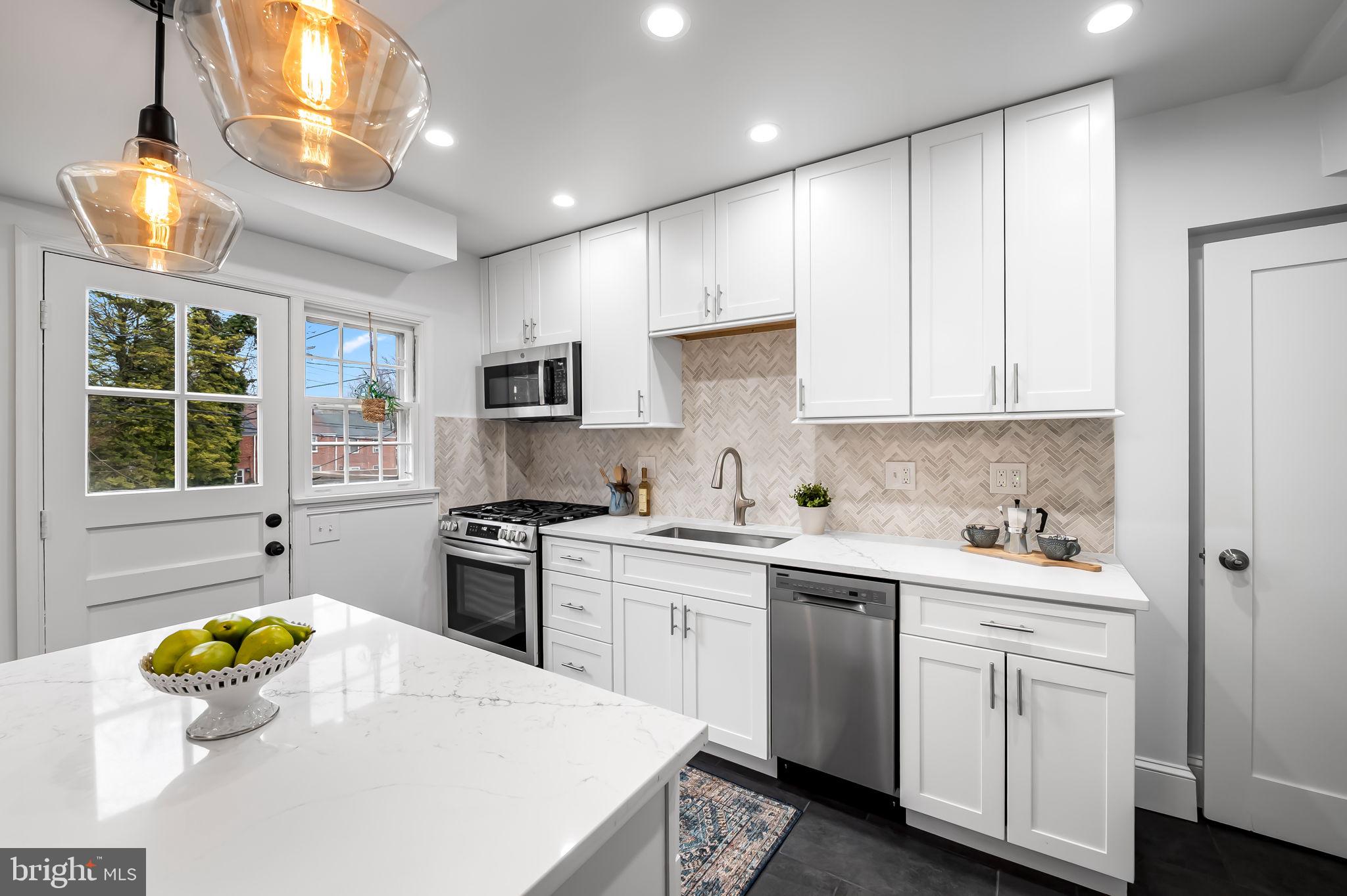834 Evesham Avenue Baltimore, MD 21212 - Photo 9 of 37 a kitchen with a stove a sink a center island and a window