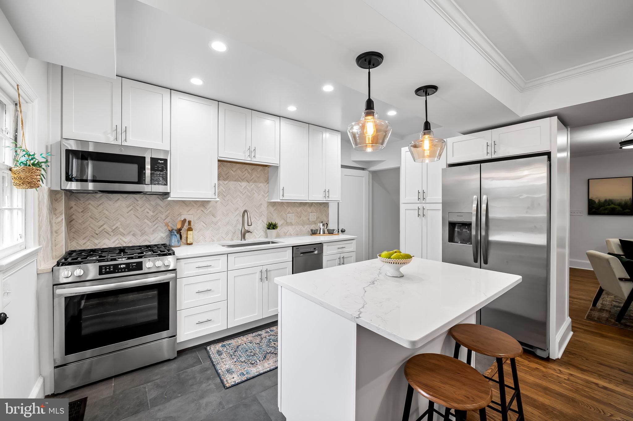 834 Evesham Avenue Baltimore, MD 21212 - Photo 10 of 37 a kitchen with a stove a refrigerator and a dining table with wooden floor