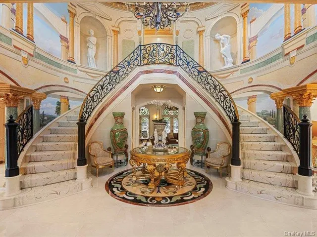 a living room with furniture a chandelier and a fireplace