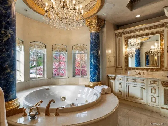 a bathroom with a tub a double vanity sink and a large mirror