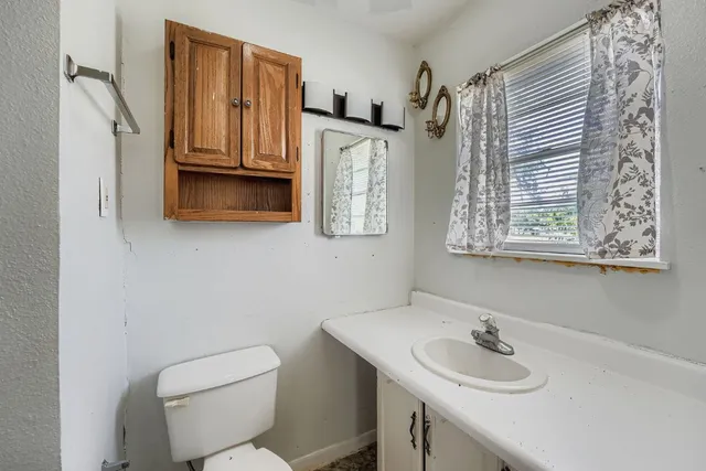 a bathroom with a toilet sink and mirror
