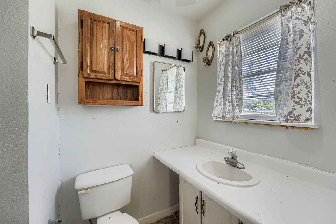 700 Blanco Street Kyle, TX 78640 - Photo 15 of 29 a bathroom with a toilet sink and mirror