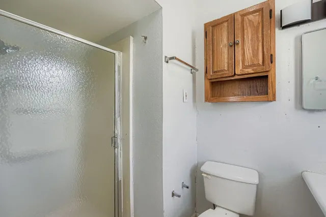 a bathroom with a granite countertop toilet and a shower