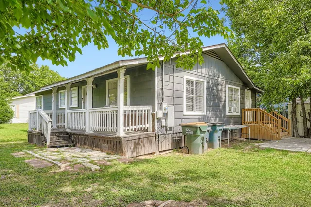 a view of a house with a yard and a deck
