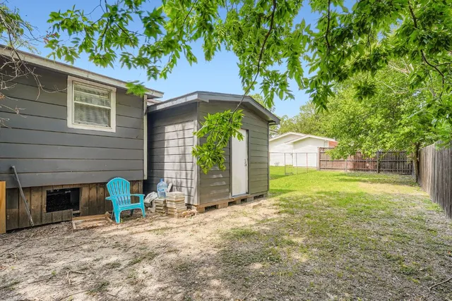 a view of a house with backyard and a tree