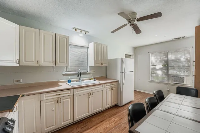 a kitchen with a sink window and cabinets