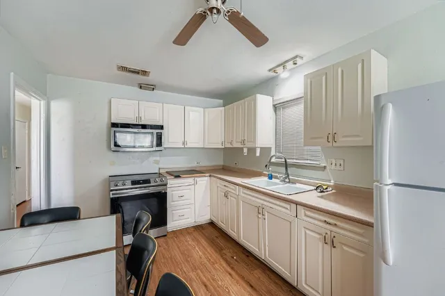 a kitchen with a sink appliances and cabinets
