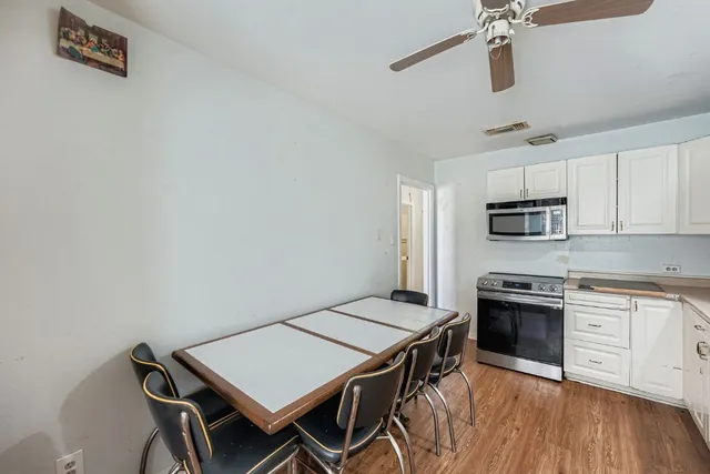 a kitchen with cabinets appliances and wooden floor