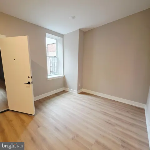 an empty room with wooden floor and window