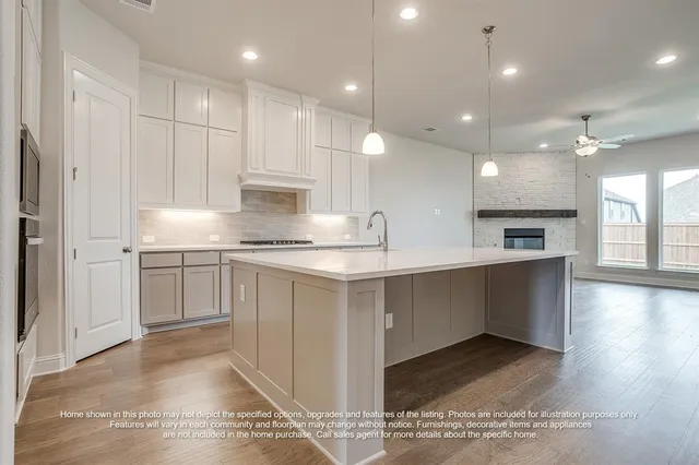 a kitchen with kitchen island white cabinets and stainless steel appliances