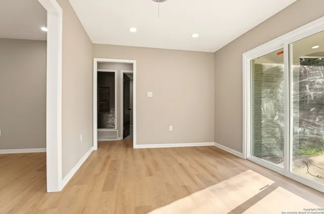 a view of hallway with a large window and wooden floor
