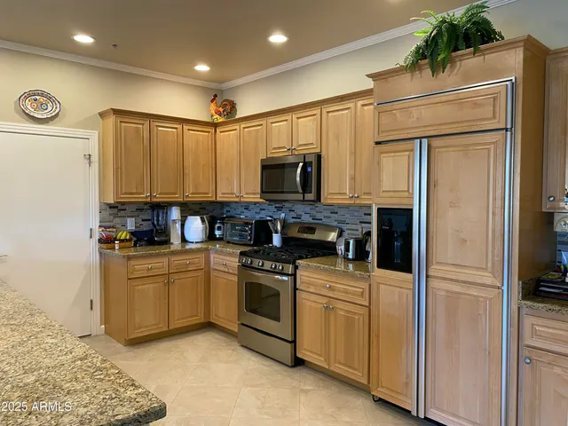 a kitchen with stainless steel appliances granite countertop a stove a sink and a refrigerator
