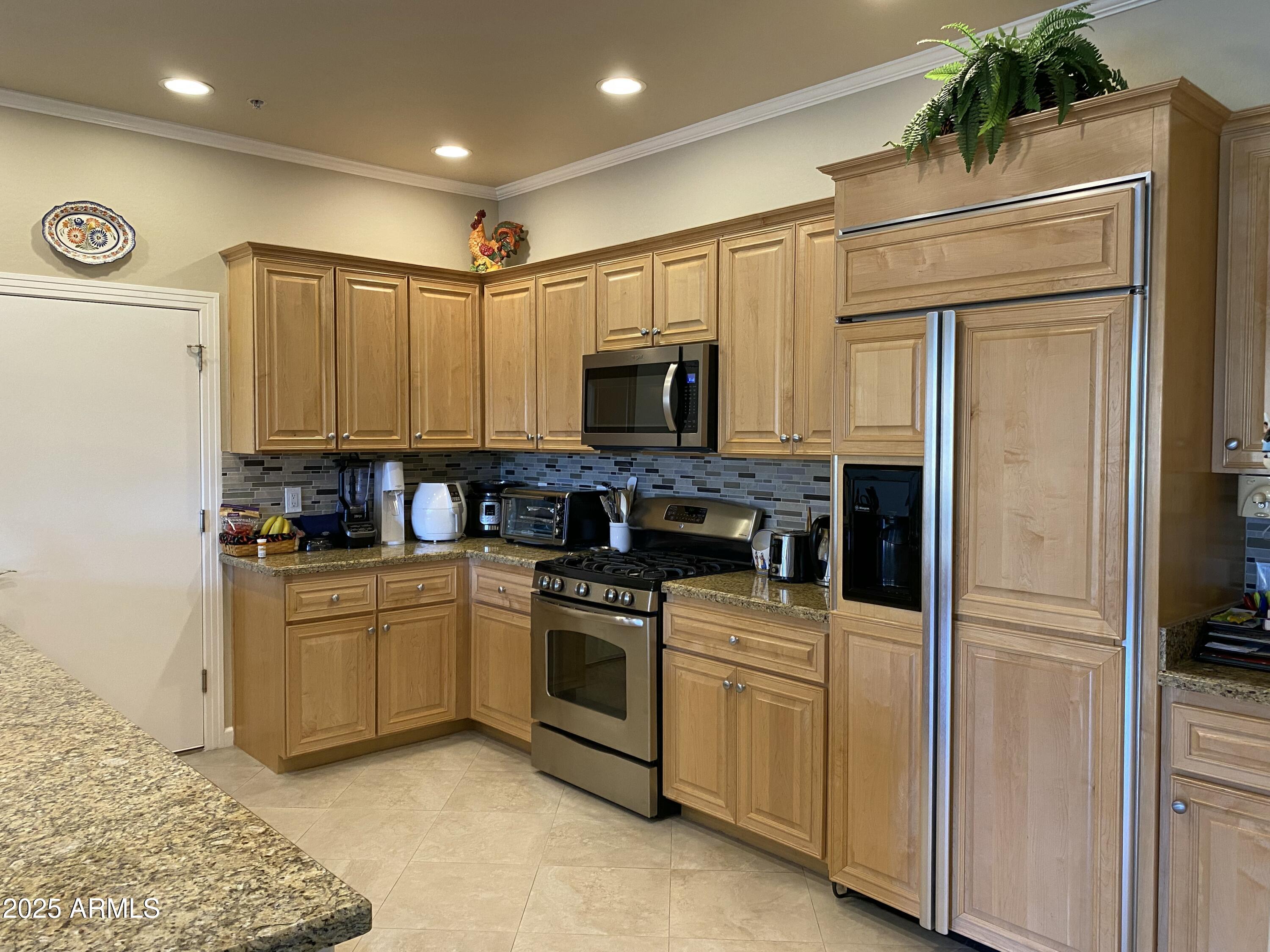 a kitchen with stainless steel appliances granite countertop a stove a sink and a refrigerator
