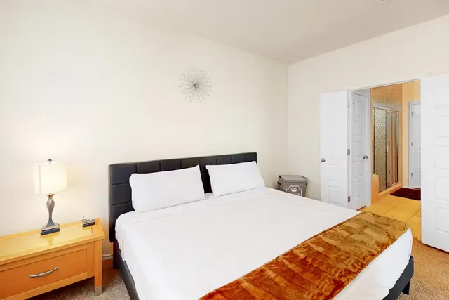 a bedroom with a bed and a night stand