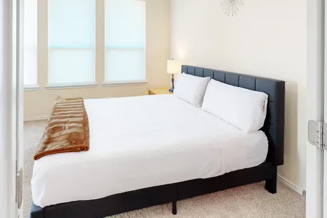 a large bed sitting in a bedroom next to a window