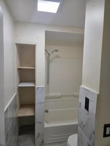 a bathroom with a tub and toilet