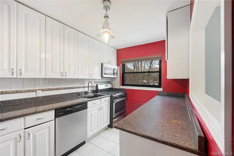 a kitchen with stainless steel appliances granite countertop a refrigerator and a stove