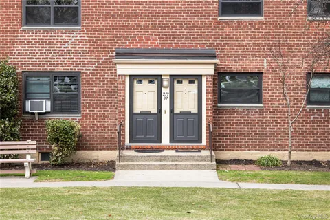 a view of a brick house with a yard