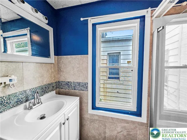 a bathroom with a sink a window and a mirror