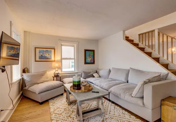 a living room with furniture and a wooden floor