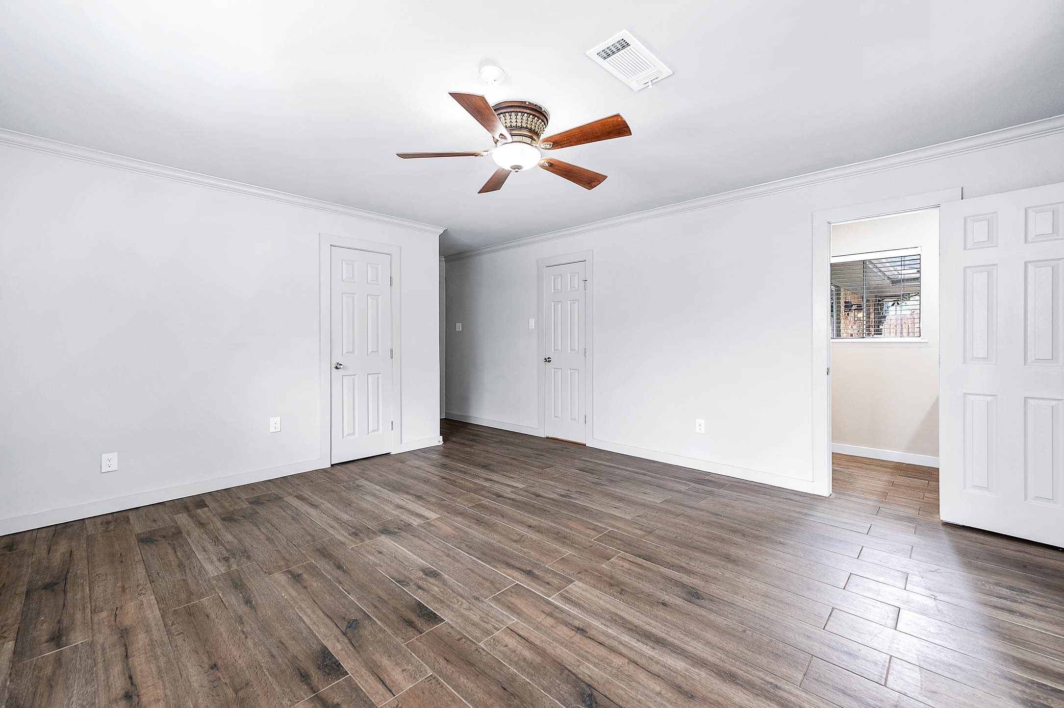6030 Warm Springs Road Houston, TX 77035 - Photo 27 of 40 an empty room with wooden floor fan and windows