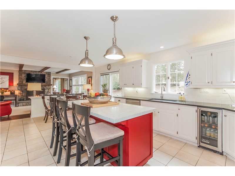 145 Marvin Ridge Road New Canaan, CT 06840 - Photo 9 of 24 a kitchen with stainless steel appliances a dining table chairs and white cabinets