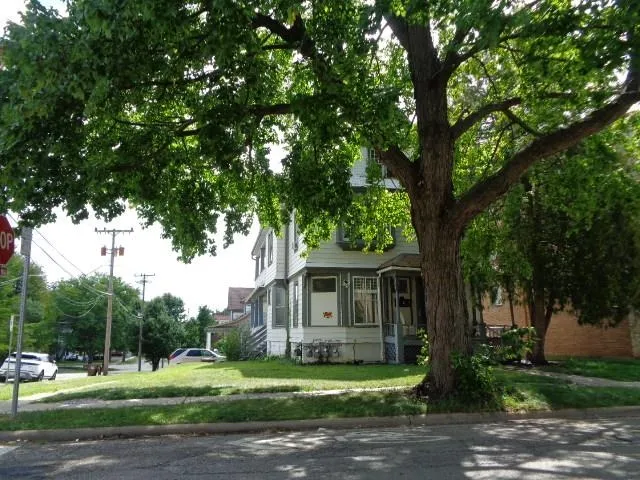 a front view of a house with a garden and trees
