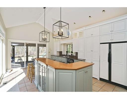 a kitchen with stainless steel appliances a sink a stove a refrigerator cabinets and living room view